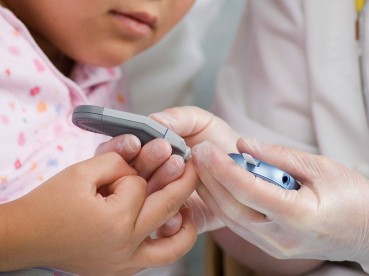nurse testing childs blood sugars