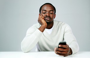 Young man bored looking at his smart phone