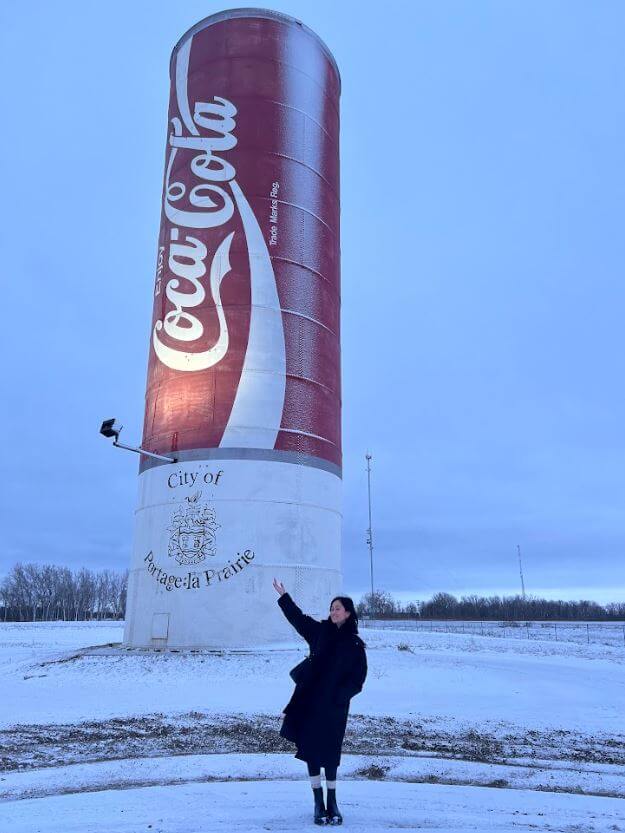 Filipino women standing beside a giant coca-cola can