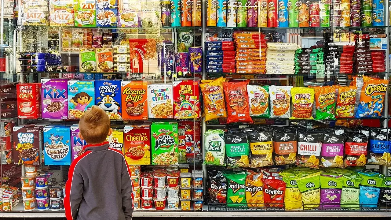 child looking at unhealthy foods on market shelves